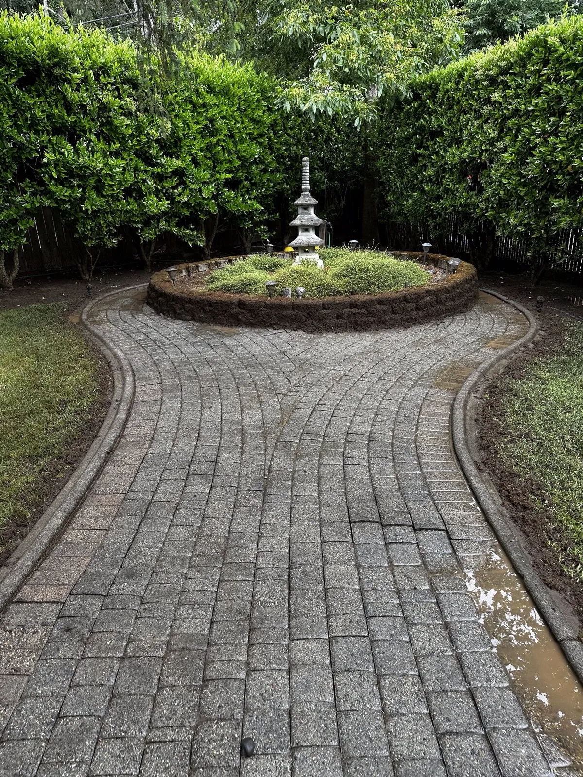 Curved paver walkway clean around a garden bed